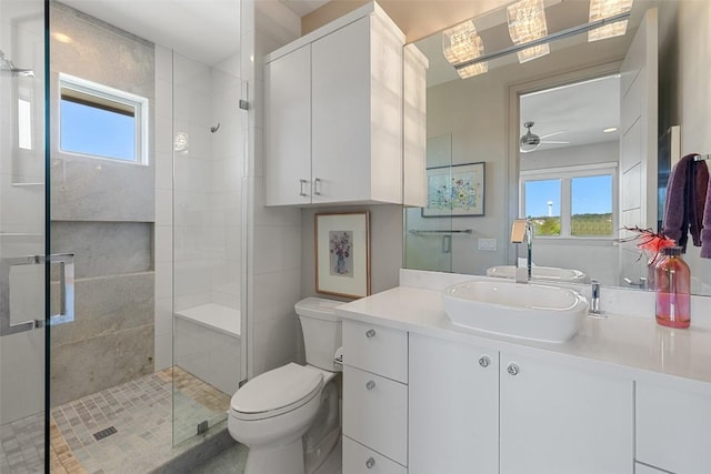 full bath with a shower stall, toilet, vanity, and ceiling fan