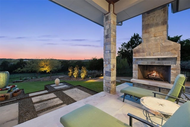 view of patio featuring fence and an outdoor stone fireplace