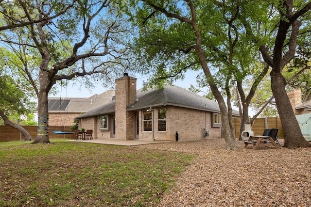 7306 Holly Fern Cv, Austin, TX 78750 - rear view of property featuring brick siding, a patio, a shingled roof, a fenced backyard, and a chimney