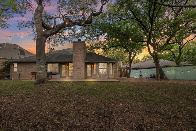 7306 Holly Fern Cv, Austin, TX 78750 - back of property featuring a chimney, brick siding, a patio area, and roof with shingles