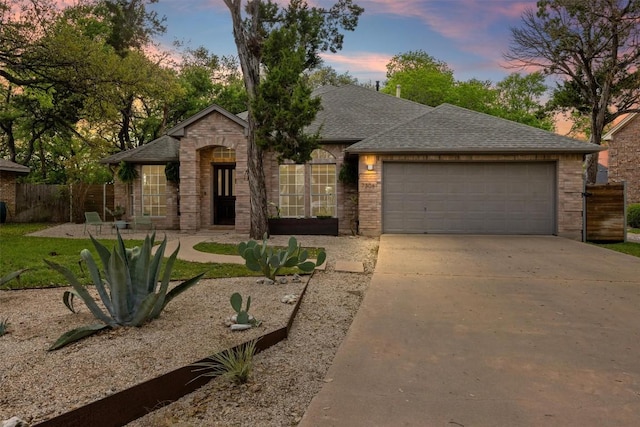 7306 Holly Fern Cv, Austin, TX 78750 - view of front of property with driveway, a garage, brick siding, and a shingled roof