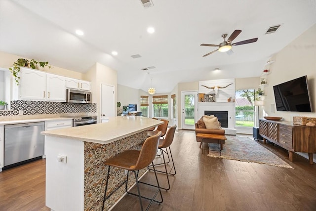 7306 Holly Fern Cv, Austin, TX 78750 - kitchen with stainless steel appliances, vaulted ceiling, white cabinets, open floor plan, and ceiling fan