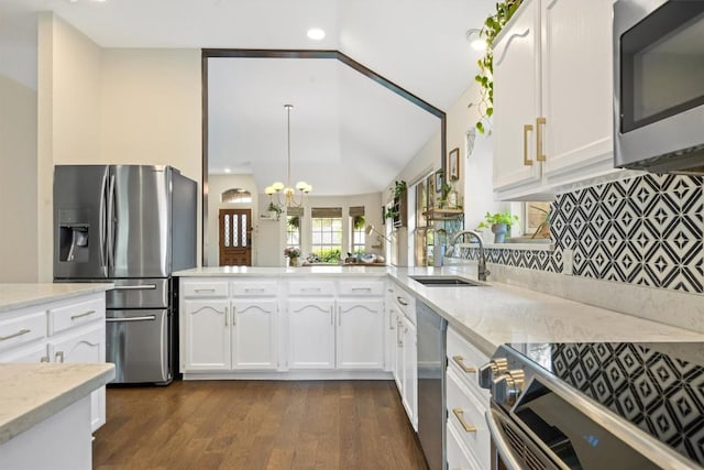7306 Holly Fern Cv, Austin, TX 78750 - kitchen with stainless steel appliances, white cabinetry, dark wood finished floors, light stone countertops, and vaulted ceiling
