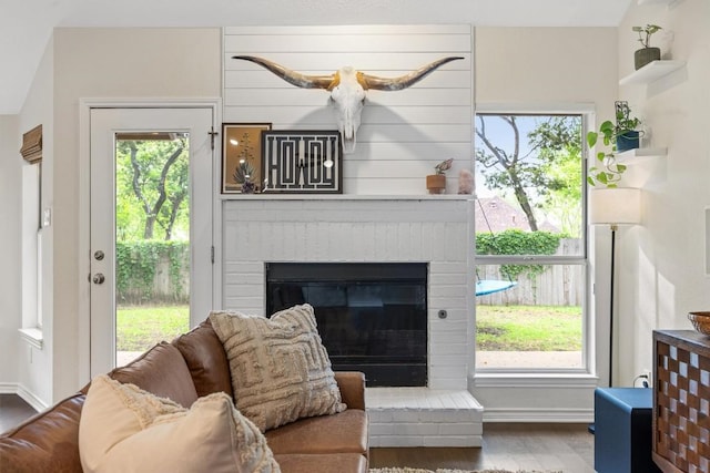 7306 Holly Fern Cv, Austin, TX 78750 - living room with wood finished floors, a brick fireplace, and plenty of natural light