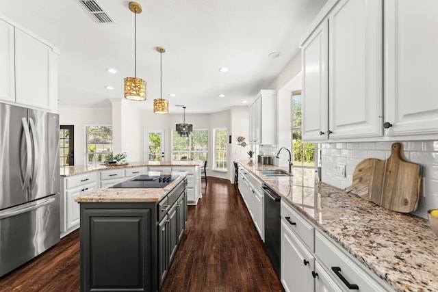6 Dovedale Cv, The Hills, TX 78738 - kitchen with freestanding refrigerator, black electric cooktop, white cabinets, backsplash, and dark wood-style floors