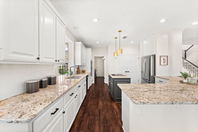 6 Dovedale Cv, The Hills, TX 78738 - kitchen featuring freestanding refrigerator, dark wood-style flooring, a kitchen island, decorative backsplash, and white cabinetry