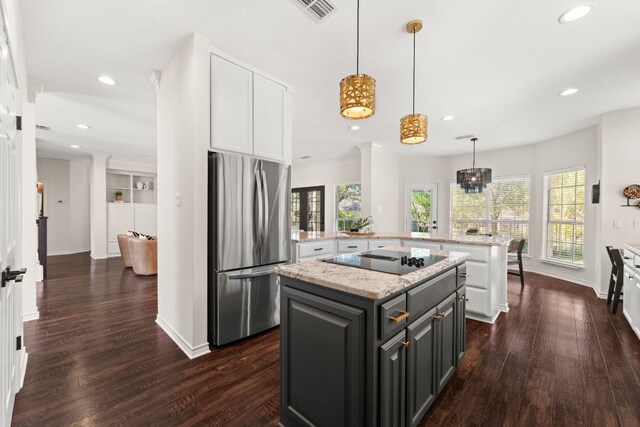 6 Dovedale Cv, The Hills, TX 78738 - kitchen with freestanding refrigerator, black electric stovetop, white cabinets, a center island, and dark wood-style flooring