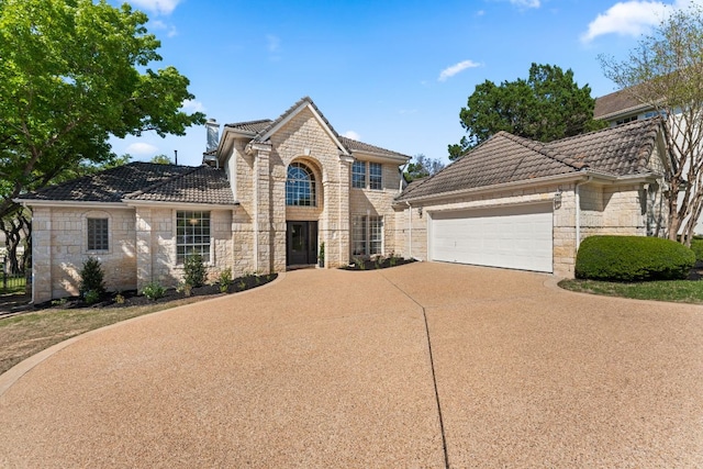 6 Dovedale Cv, The Hills, TX 78738 - traditional home with stone siding, a tile roof, concrete driveway, and an attached garage