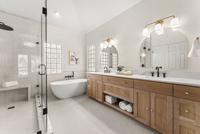 6 Dovedale Cv, The Hills, TX 78738 - full bathroom featuring double vanity, a shower stall, a soaking tub, and vaulted ceiling