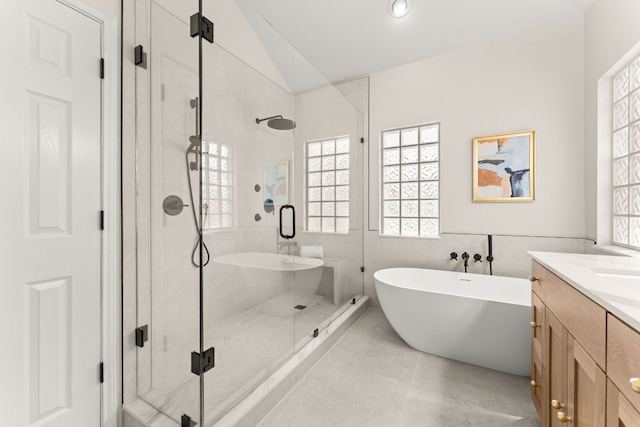 6 Dovedale Cv, The Hills, TX 78738 - bathroom with plenty of natural light, a shower stall, a soaking tub, and vaulted ceiling
