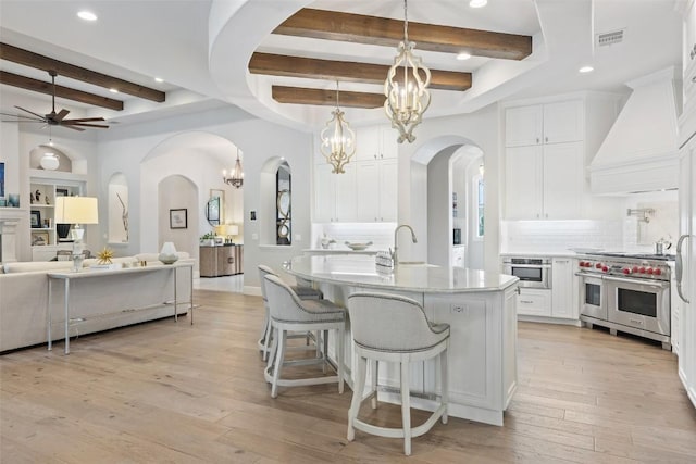 212 Bella Cima Dr, Austin, TX 78734 - kitchen with appliances with stainless steel finishes, a chandelier, beamed ceiling, premium range hood, and open floor plan