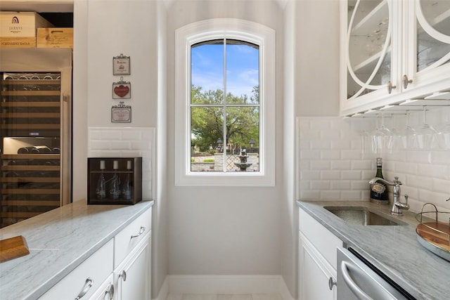 212 Bella Cima Dr, Austin, TX 78734 - kitchen featuring dishwasher, tasteful backsplash, light stone countertops, white cabinets, and glass insert cabinets