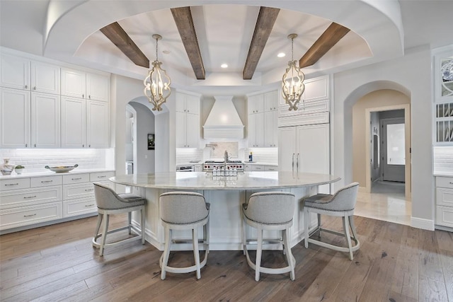 212 Bella Cima Dr, Austin, TX 78734 - kitchen featuring custom exhaust hood, a chandelier, arched walkways, beam ceiling, and white cabinetry