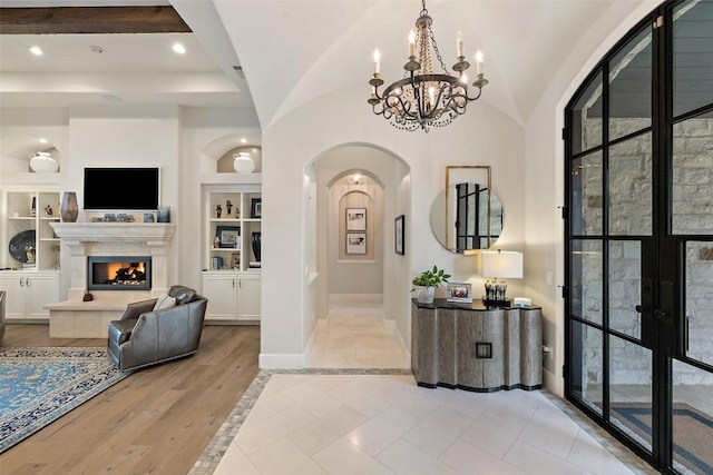 212 Bella Cima Dr, Austin, TX 78734 - foyer entrance featuring arched walkways, a chandelier, recessed lighting, a tile fireplace, and french doors