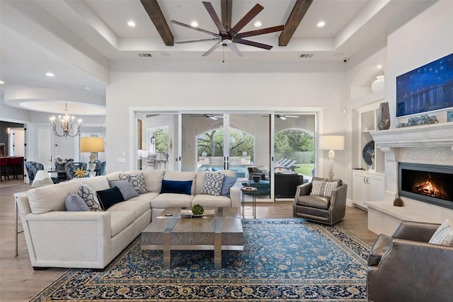 212 Bella Cima Dr, Austin, TX 78734 - living room with ceiling fan, wood finished floors, beamed ceiling, a chandelier, and a fireplace