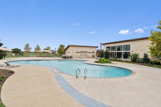 community pool featuring fence and a patio