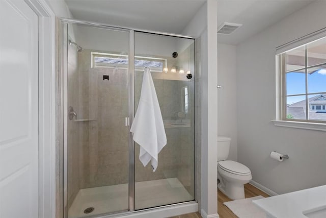 full bathroom with a shower stall, toilet, and visible vents