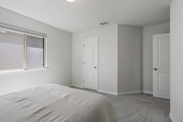carpeted bedroom with baseboards and visible vents