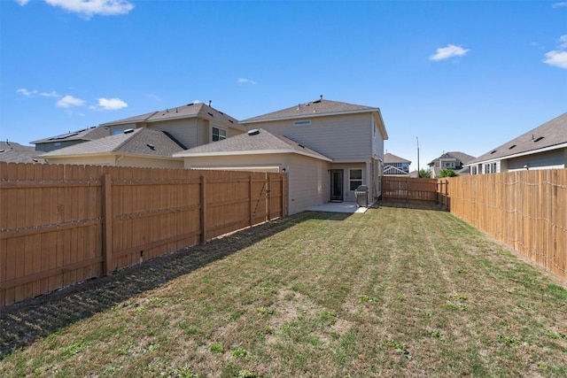 back of house featuring a lawn and a fenced backyard