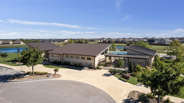 view of front of house featuring curved driveway, stone siding, and a residential view