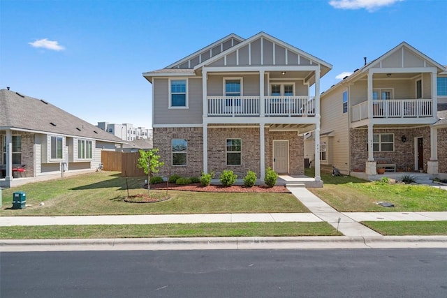 view of front of home featuring fence, board and batten siding, brick siding, and a front yard