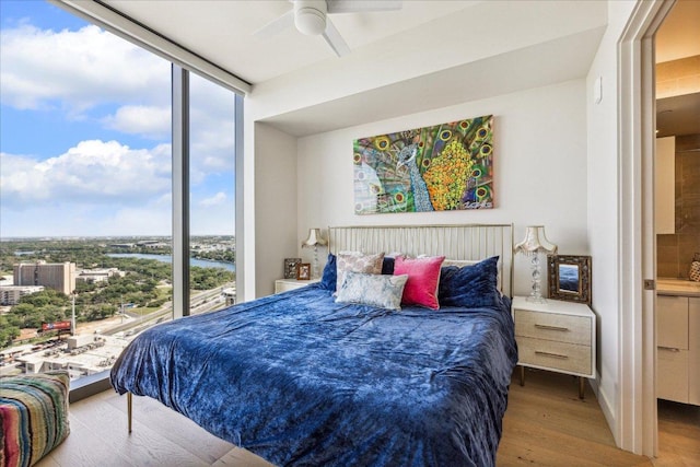44 E Ave Unit 2509, Austin, TX 78701 - bedroom with a wall of windows, multiple windows, wood finished floors, and a ceiling fan