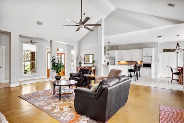 119 Maple Leaf Trl, Elgin, TX 78621 - living area with high vaulted ceiling, ceiling fan, concrete flooring, and a chandelier