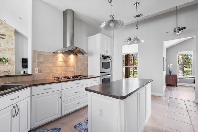 119 Maple Leaf Trl, Elgin, TX 78621 - kitchen with wall chimney range hood, dark countertops, appliances with stainless steel finishes, light tile patterned flooring, and high vaulted ceiling