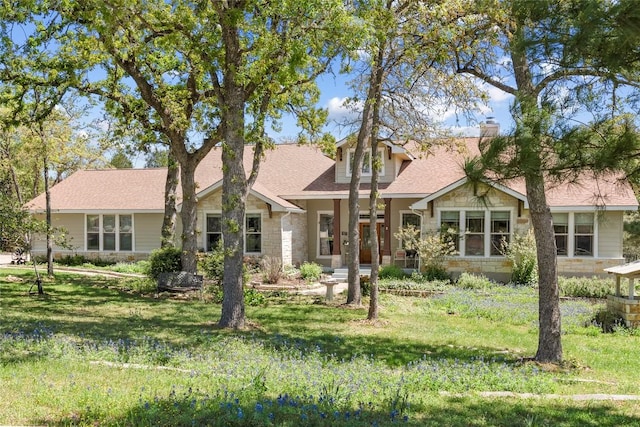 119 Maple Leaf Trl, Elgin, TX 78621 - view of front of house with stone siding, a front lawn, a chimney, and a shingled roof
