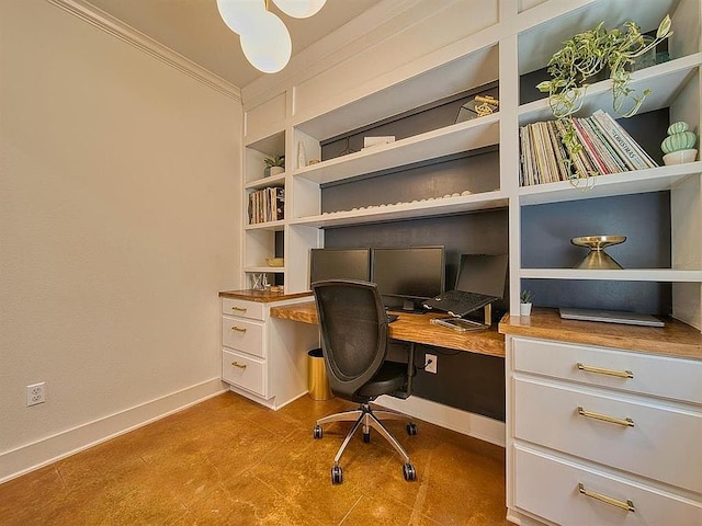 office featuring crown molding, built in study area, built in shelves, and baseboards