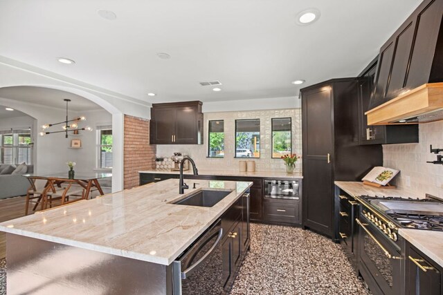 6009 Grover Ave, Austin, TX 78757 - kitchen with a sink, stainless steel appliances, premium range hood, light stone counters, and recessed lighting