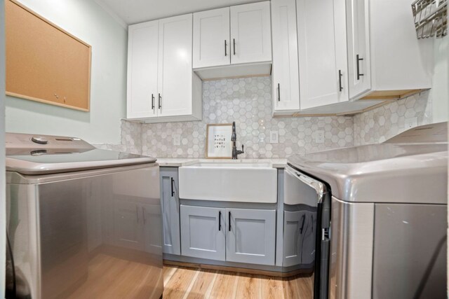 6009 Grover Ave, Austin, TX 78757 - kitchen with a sink, washer and dryer, light countertops, and light wood-style floors