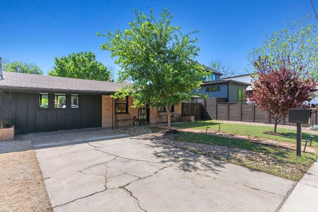 6009 Grover Ave, Austin, TX 78757 - view of front facade with board and batten siding, concrete driveway, and brick siding