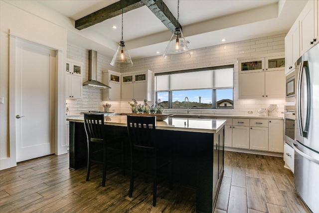 518 Doe Whisper Way, Austin, TX 78738 - kitchen featuring wall chimney range hood, backsplash, appliances with stainless steel finishes, dark wood finished floors, and beamed ceiling