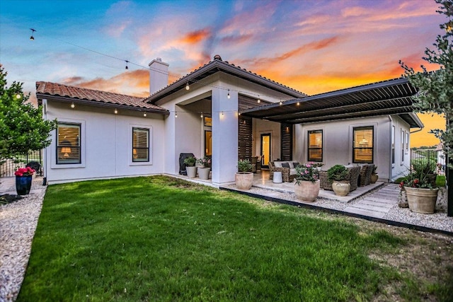 518 Doe Whisper Way, Austin, TX 78738 - back of property at dusk with a chimney, stucco siding, a tile roof, and a patio