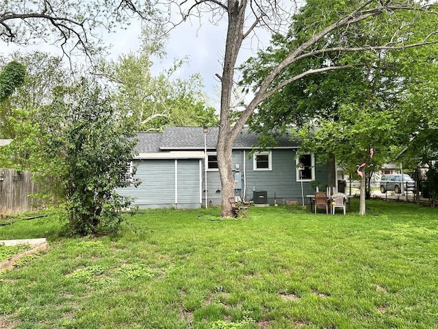 716 Barbara Dr, San Marcos, TX 78666 - back of house featuring fence, cooling unit, a shingled roof, and a lawn