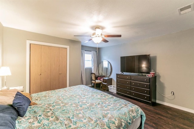bedroom featuring ceiling fan, dark wood finished floors, a closet, visible vents, and baseboards