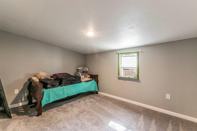 bedroom with cooling unit, baseboards, and carpet floors