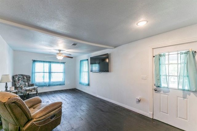 interior space featuring visible vents, baseboards, dark wood-style flooring, a ceiling fan, and a textured ceiling
