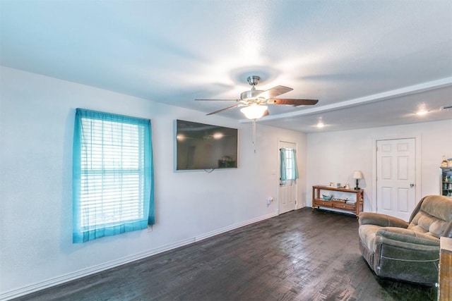 sitting room with baseboards, a ceiling fan, and dark wood finished floors