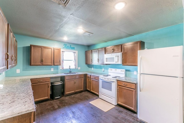 kitchen featuring a sink, light countertops, white appliances, and a textured ceiling