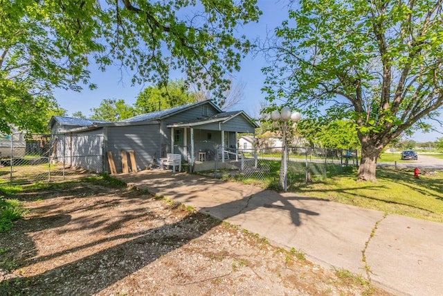 rear view of property with fence, a lawn, and driveway