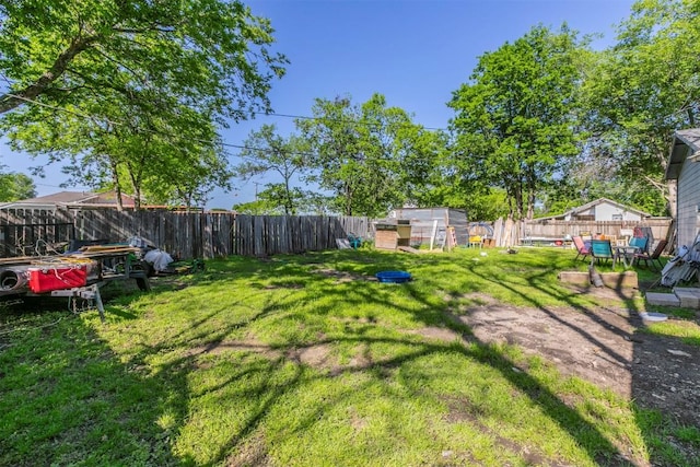 view of yard featuring a fenced backyard and an outbuilding