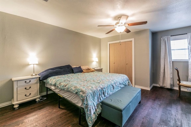 bedroom with a closet, dark wood-style flooring, baseboards, and a ceiling fan