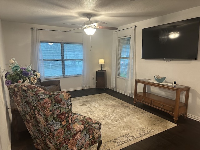 409 E Houston St, Mexia, TX 76667 - living area with dark wood finished floors, ceiling fan, healthy amount of natural light, and a textured ceiling