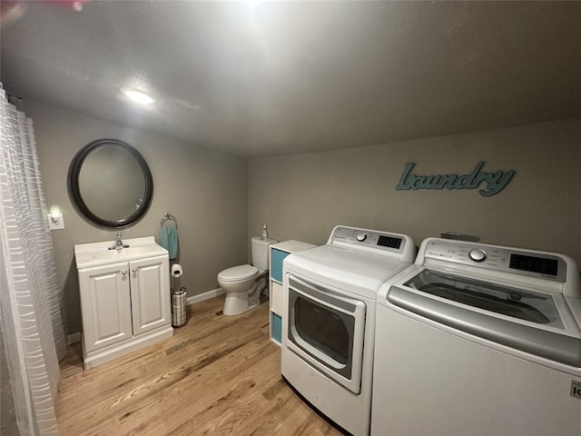 409 E Houston St, Mexia, TX 76667 - washroom featuring washer and clothes dryer, light wood-type flooring, and baseboards