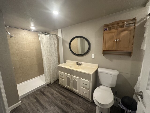 409 E Houston St, Mexia, TX 76667 - full bathroom with wood finished floors, vanity, toilet, and a tile shower