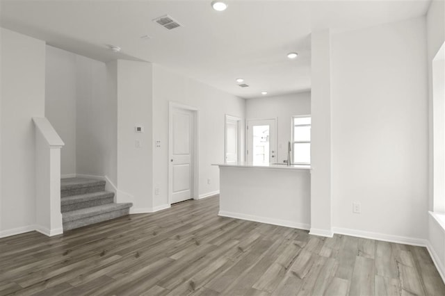 124 Rollingwood Dr, San Marcos, TX 78666 - unfurnished living room with wood finished floors, stairs, recessed lighting, and baseboards