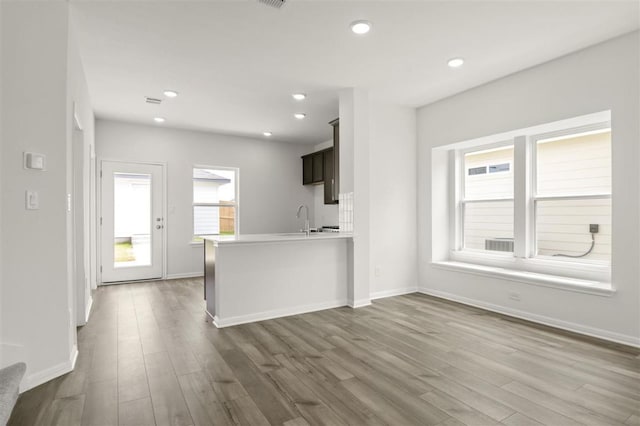 124 Rollingwood Dr, San Marcos, TX 78666 - kitchen with dark wood-style flooring, light countertops, baseboards, a sink, and a peninsula