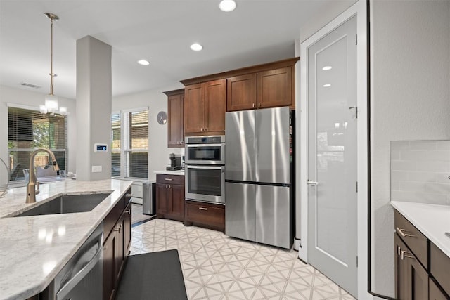 104 Atlanta Park Dr, Georgetown, TX 78628 - kitchen with stainless steel appliances, a sink, a chandelier, light flooring, and hanging light fixtures
